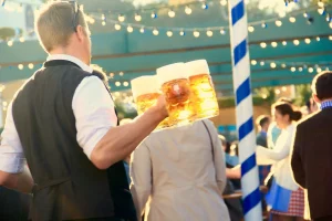 En mann bærer flere litersglass på oktoberfest